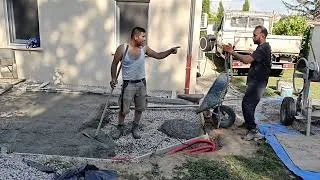 Miniature : Le maçon lise le béton de la dalle grâce à sa règle de maçon 