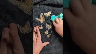 Miniature : Papillons dorés brodés sur une serviette noire, motif Urban Threads